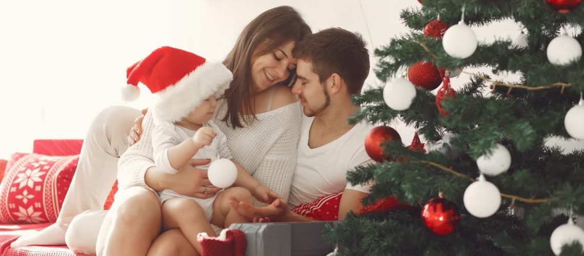 A family bonding together by the Christmas tree, embracing holiday spirit indoors.